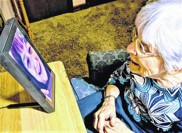 Elderly woman video calling family
