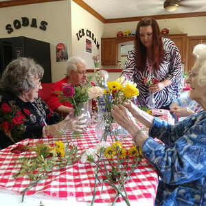Women Putting Together Flowers In Vases
