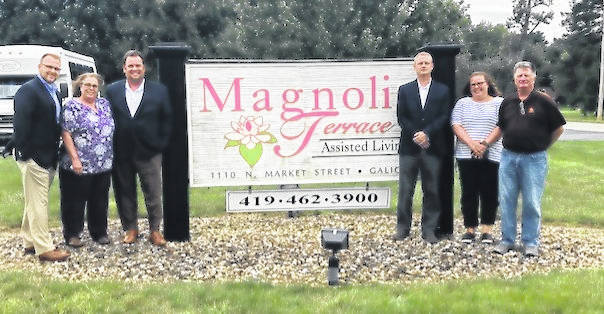 a group of people standing in front of Magnolia terrace sign