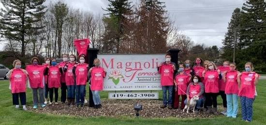 a group of people standing in front of Magnolia Terrace sign